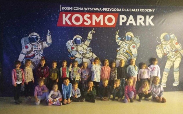 Dzieci stoją na tle plakatu Kosmoparku