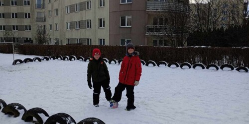 Chłopcy graja na śniegu w piłkę nożną