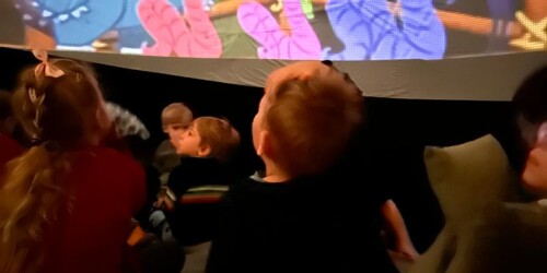 Dzieci oglądają pokaz wyświetlany wewnątrz kopuły